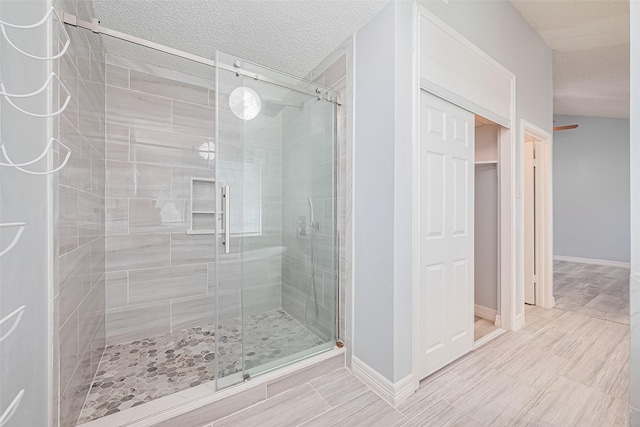 2115 Streamcrest Ln, Sugar Land, TX 77479 - full bathroom featuring a stall shower, baseboards, and a walk in closet