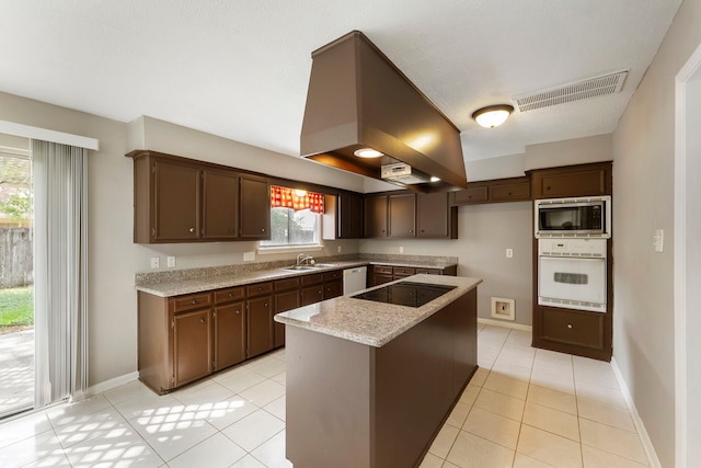 4807 Wind Chimes Dr, Houston, TX 77066 - kitchen with white appliances, a sink, island exhaust hood, light tile patterned flooring, and a center island