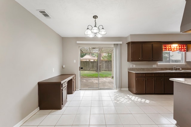 4807 Wind Chimes Dr, Houston, TX 77066 - kitchen with a sink, dark brown cabinetry, a chandelier, baseboards, and decorative light fixtures