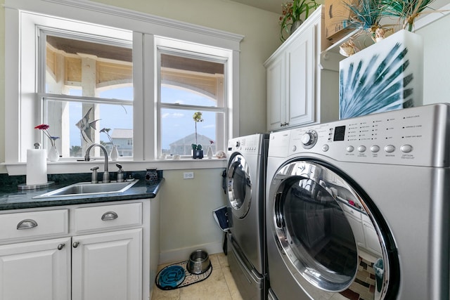 4115 Sand Hill Ct, Galveston, TX 77554 - laundry area featuring washing machine and dryer, cabinet space, baseboards, and light tile patterned floors