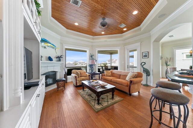 4115 Sand Hill Ct, Galveston, TX 77554 - living area featuring wood ceiling, a raised ceiling, healthy amount of natural light, a premium fireplace, and arched walkways