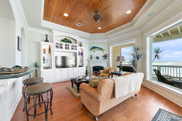 4115 Sand Hill Ct, Galveston, TX 77554 - living area with a raised ceiling, wooden ceiling, ornamental molding, a fireplace, and light wood-style floors