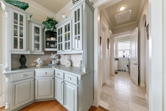 4115 Sand Hill Ct, Galveston, TX 77554 - bar with crown molding, decorative backsplash, and light tile patterned floors