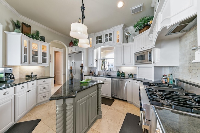 4115 Sand Hill Ct, Galveston, TX 77554 - kitchen with built in appliances, tasteful backsplash, a sink, white cabinets, and crown molding