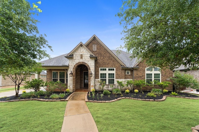10110 Da Vinci Ct, Iowa Colony, TX 77583 - view of front of home featuring a front yard, stone siding, and roof with shingles