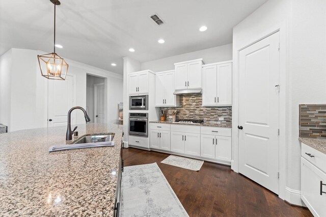 10110 Da Vinci Ct, Iowa Colony, TX 77583 - kitchen with appliances with stainless steel finishes, a sink, tasteful backsplash, white cabinets, and recessed lighting