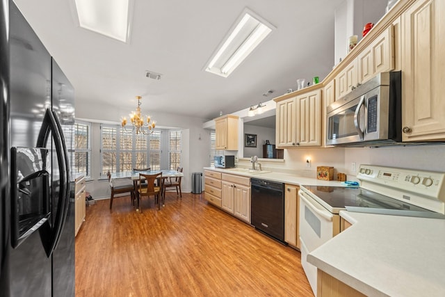125 Terrace Ln E, Kerrville, TX 78028 - kitchen with black appliances, a chandelier, light wood-style flooring, and light countertops