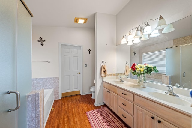 125 Terrace Ln E, Kerrville, TX 78028 - full bathroom featuring double vanity, a garden tub, a stall shower, wood finished floors, and toilet
