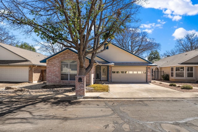 125 Terrace Ln E, Kerrville, TX 78028 - ranch-style house with brick siding, concrete driveway, and an attached garage