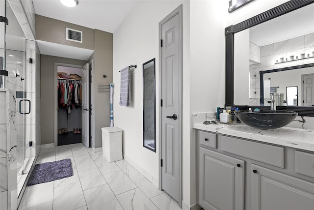 14314 Strutton Dr, Sugar Land, TX 77498 - bathroom with marble look tile flooring, a stall shower, vanity, and a walk in closet