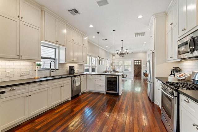 807 Vincent St, Houston, TX 77009 - kitchen featuring stainless steel appliances, beverage cooler, dark countertops, a sink, and a peninsula