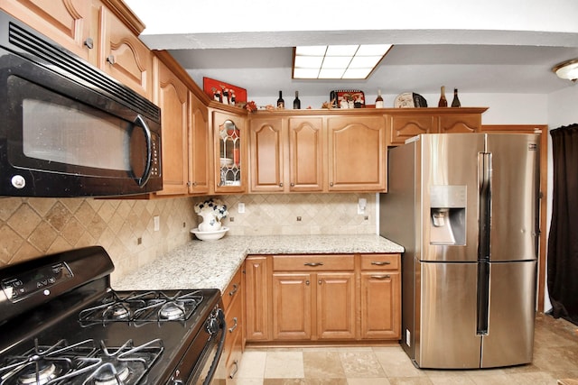 1110 E Brown Ln, Deer Park, TX 77536 - kitchen featuring black appliances, light stone countertops, glass insert cabinets, backsplash, and brown cabinets