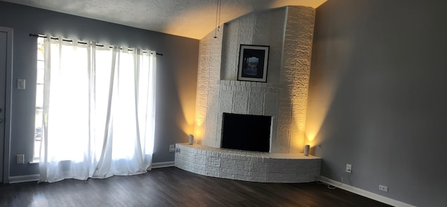 913 N Amy Dr, Deer Park, TX 77536 - unfurnished living room with a brick fireplace, dark wood-style floors, baseboards, and lofted ceiling