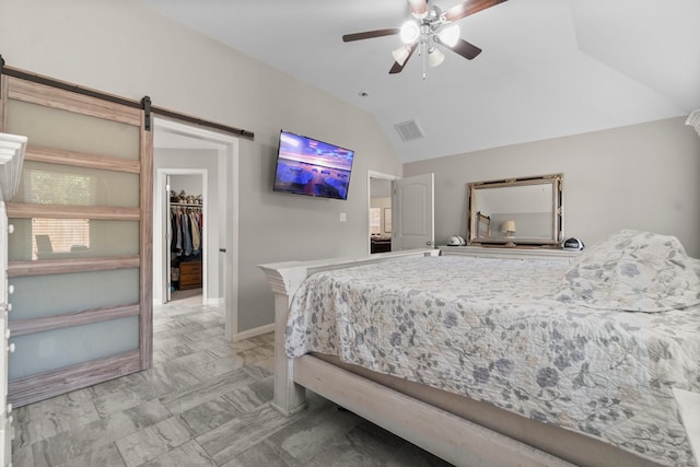 28987 Birch Green Way, Spring, TX 77386 - bedroom featuring lofted ceiling, a barn door, ceiling fan, a walk in closet, and baseboards