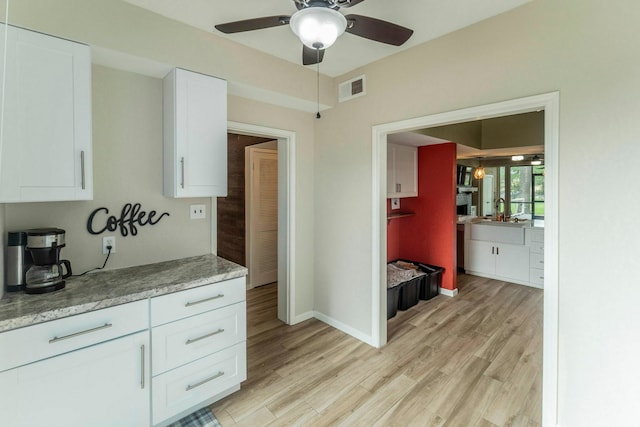 2304 Keel Ct, Willis, TX 77318 - kitchen featuring white cabinetry, a ceiling fan, light wood-type flooring, and baseboards