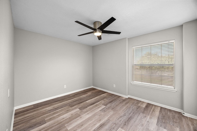 612 Hartman Dr, Baytown, TX 77521 - unfurnished room featuring wood finished floors, baseboards, a ceiling fan, and a textured ceiling