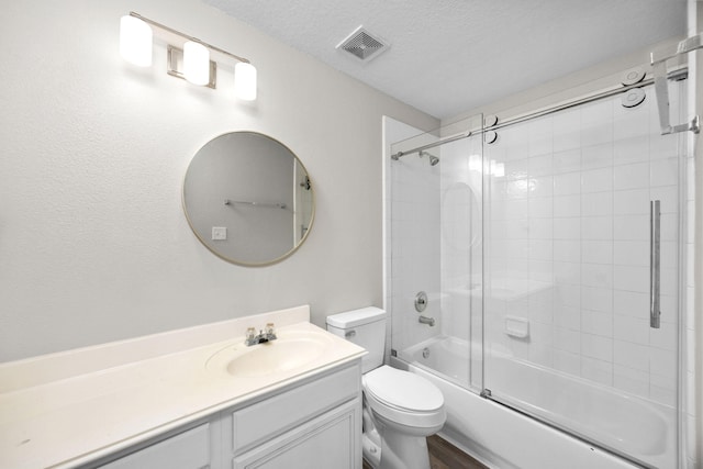 612 Hartman Dr, Baytown, TX 77521 - bathroom featuring vanity, combined bath / shower with glass door, toilet, and a textured ceiling