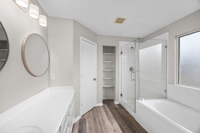 612 Hartman Dr, Baytown, TX 77521 - bathroom with a shower stall, a bath, wood finished floors, vanity, and baseboards