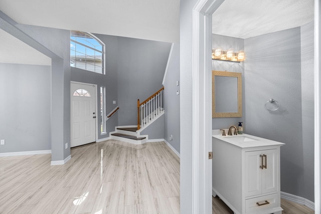 612 Hartman Dr, Baytown, TX 77521 - entryway with light wood finished floors, baseboards, and stairs