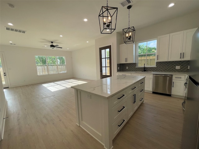 6412 Highland Pine Ln, Houston, TX 77091 - kitchen featuring stainless steel dishwasher, a sink, light wood-style flooring, tasteful backsplash, and recessed lighting