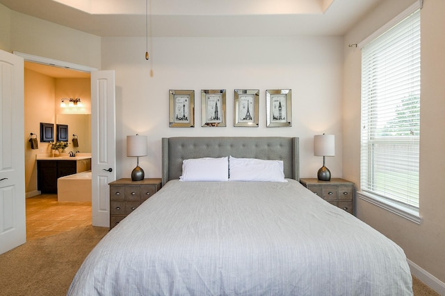 2800 Spencer Ct, Pearland, TX 77089 - carpeted bedroom featuring multiple windows, baseboards, ensuite bath, and tile patterned flooring