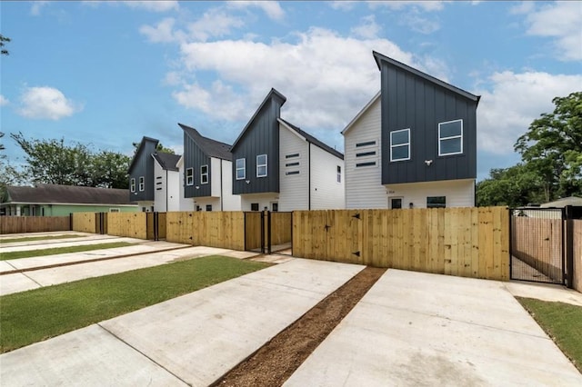 2704 Bostic St, Houston, TX 77093 - view of side of property with board and batten siding, a gate, a fenced front yard, and a residential view