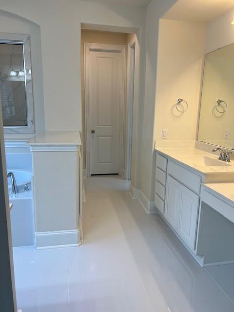 10255 S Goshawk Trl, Conroe, TX 77385 - bathroom featuring vanity, a bath, and baseboards