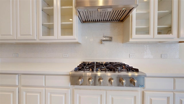 10255 S Goshawk Trl, Conroe, TX 77385 - kitchen view of island range hood, stainless steel gas cooktop, light countertops, and white cabinetry