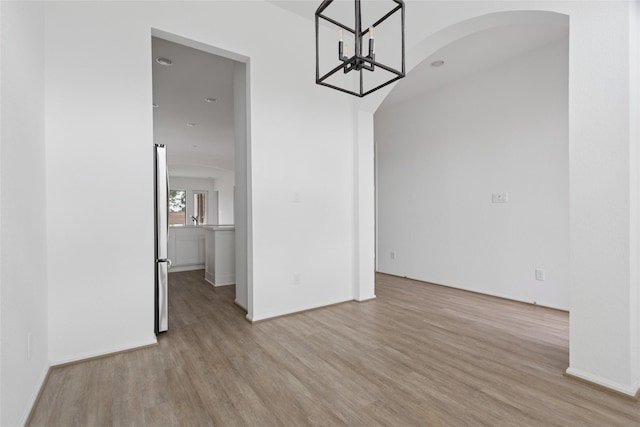 18415 Circle Bar Ranch Ct, Cypress, TX 77433 - unfurnished dining area featuring wood finished floors, arched walkways, a chandelier, and baseboards