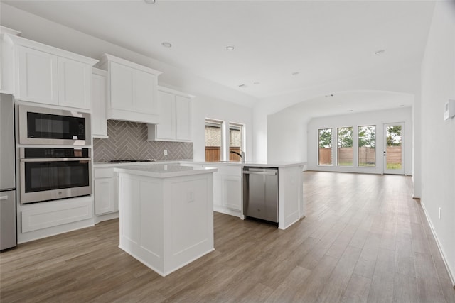 18415 Circle Bar Ranch Ct, Cypress, TX 77433 - kitchen featuring appliances with stainless steel finishes, open floor plan, a kitchen island, light wood-style flooring, and recessed lighting