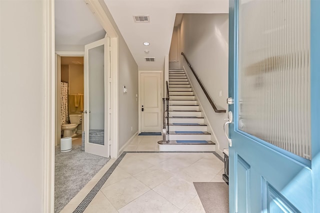 2425 Polk St, Houston, TX 77003 - foyer entrance featuring light tile patterned floors, baseboards, and stairway