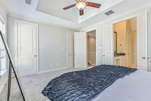 2425 Polk St, Houston, TX 77003 - carpeted bedroom featuring a raised ceiling, crown molding, ensuite bath, baseboards, and ceiling fan