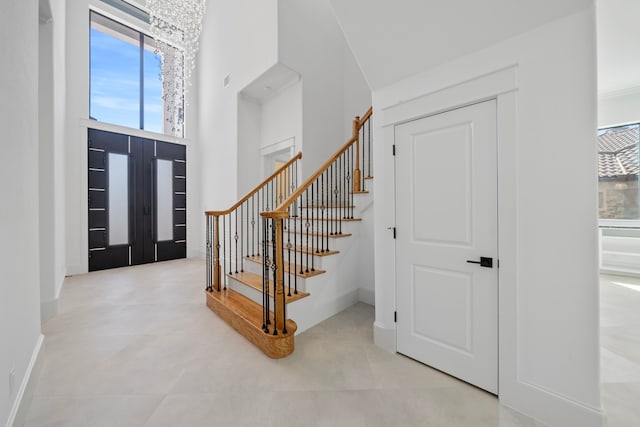 91 Lake Sterling Gate Dr, Spring, TX 77379 - foyer with healthy amount of natural light, a high ceiling, stairs, and baseboards