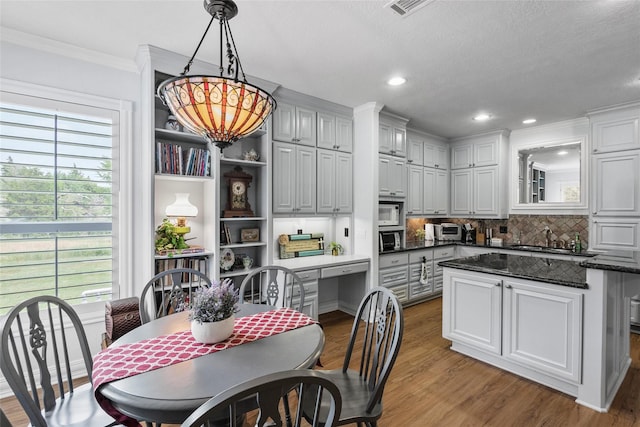 17265 Fm 2154, College Station, TX 77845 - kitchen featuring a sink, light wood-style flooring, decorative backsplash, ornamental molding, and hanging light fixtures