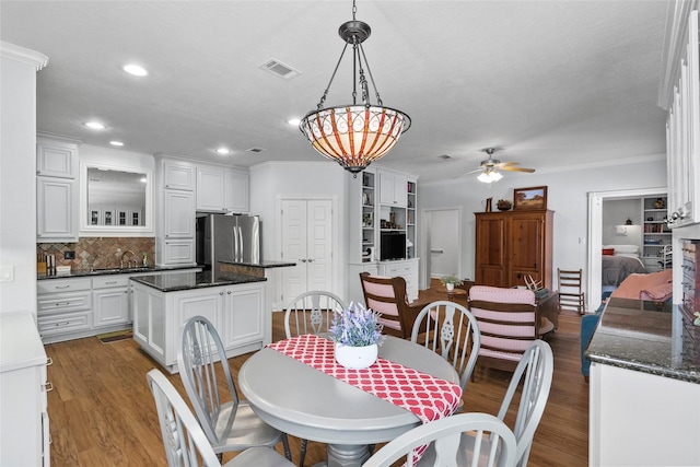 17265 Fm 2154, College Station, TX 77845 - dining space featuring wood finished floors, ceiling fan, recessed lighting, crown molding, and a chandelier