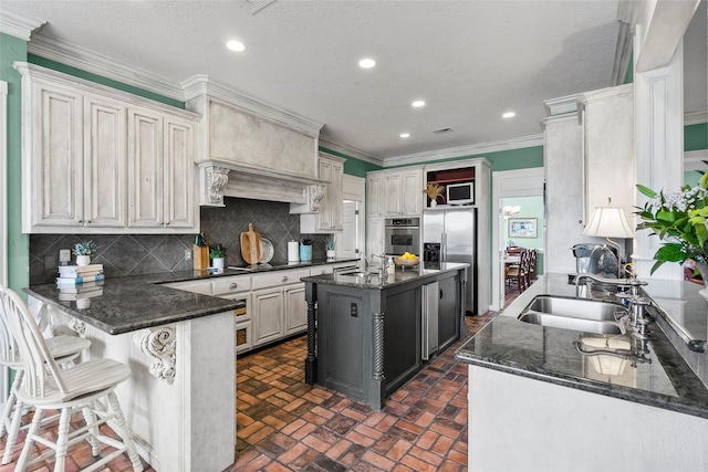 17265 Fm 2154, College Station, TX 77845 - kitchen featuring a sink, appliances with stainless steel finishes, a peninsula, brick flooring, and ornamental molding