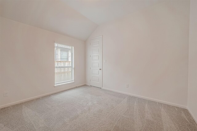 4826 Joplin St, Iowa Colony, TX 77583 - spare room featuring light colored carpet, lofted ceiling, and baseboards