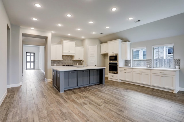 2818 Tanager Trce, Katy, TX 77493 - kitchen with stainless steel oven, white cabinetry, decorative backsplash, light countertops, and recessed lighting