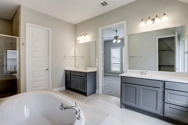 2818 Tanager Trce, Katy, TX 77493 - bathroom with a shower stall, a ceiling fan, a garden tub, two vanities, and a spacious closet