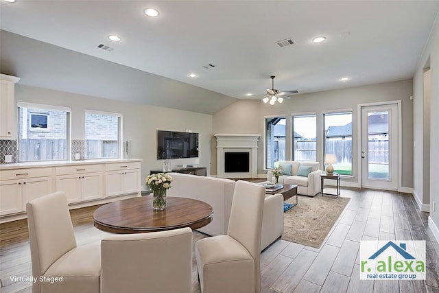 2818 Tanager Trce, Katy, TX 77493 - dining space featuring ceiling fan, light wood finished floors, recessed lighting, a fireplace, and lofted ceiling