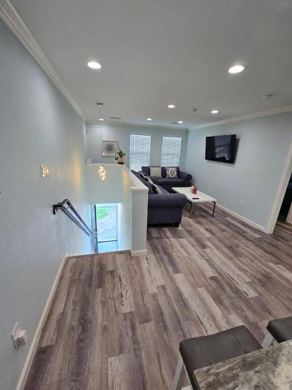 1513 47th St, Galveston, TX 77551 - living room featuring ornamental molding, baseboards, recessed lighting, and wood finished floors