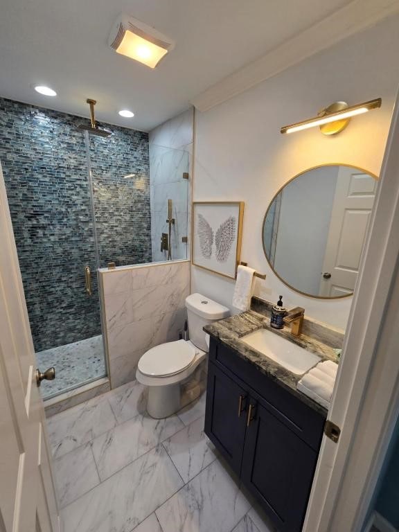 1513 47th St, Galveston, TX 77551 - bathroom with vanity, marble look tiles, a shower stall, toilet, and recessed lighting