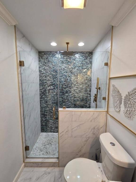 1513 47th St, Galveston, TX 77551 - full bathroom with marble look tiles, a shower stall, toilet, and recessed lighting