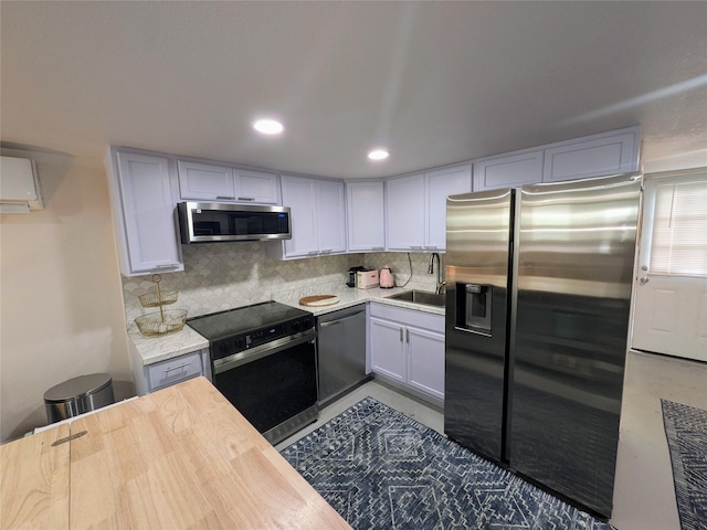 1513 47th St, Galveston, TX 77551 - kitchen featuring stainless steel appliances, backsplash, a sink, butcher block counters, and recessed lighting
