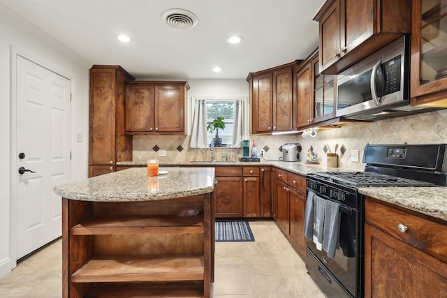 12222 23rd St, Santa Fe, TX 77510 - kitchen featuring open shelves, black gas range, stainless steel microwave, light stone counters, and recessed lighting