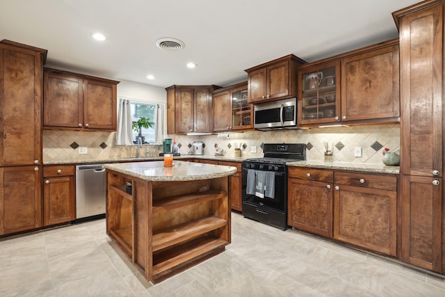 12222 23rd St, Santa Fe, TX 77510 - kitchen with stainless steel appliances, open shelves, tasteful backsplash, light stone countertops, and recessed lighting