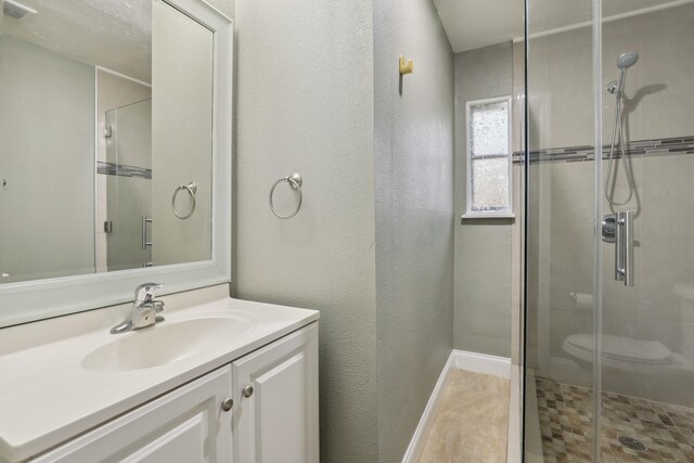 12222 23rd St, Santa Fe, TX 77510 - bathroom featuring a stall shower, vanity, toilet, baseboards, and a textured wall