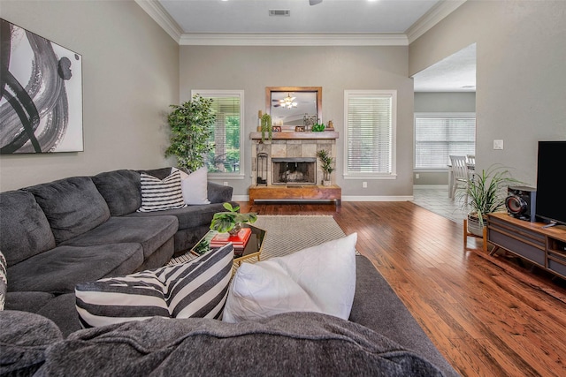 2707 Colony Creek Dr, Bryan, TX 77808 - living room with crown molding, wood finished floors, baseboards, and a tiled fireplace