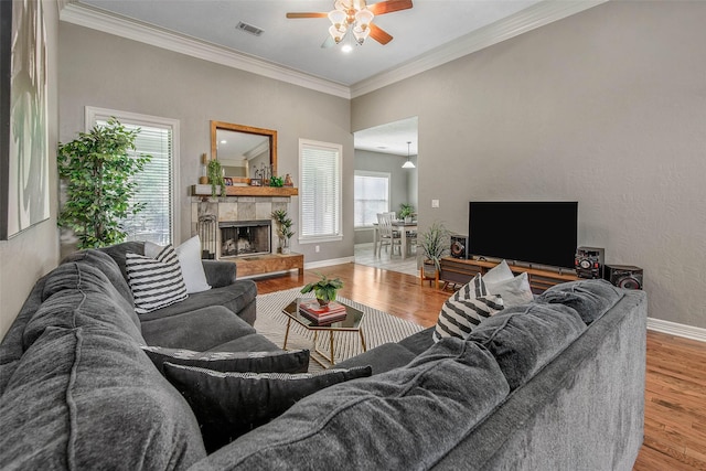 2707 Colony Creek Dr, Bryan, TX 77808 - living area with ceiling fan, wood finished floors, baseboards, ornamental molding, and a tile fireplace