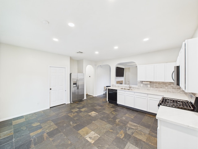 1035 Turnberry Park Ln, Spring, TX 77373 - kitchen with stainless steel appliances, arched walkways, a sink, tasteful backsplash, and recessed lighting